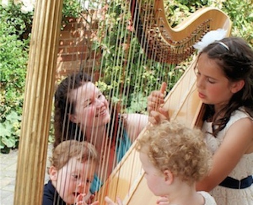 Children trying the harp at a wedding